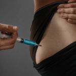Person administering an injection in the side of the abdomen, illustrating safe steroid injection practices related to muscle building and athletic performance.